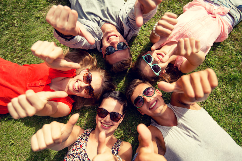 english phrases I'm easy people lying on the grass with their thumbs up