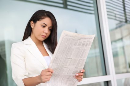 A woman reading a student newspaper