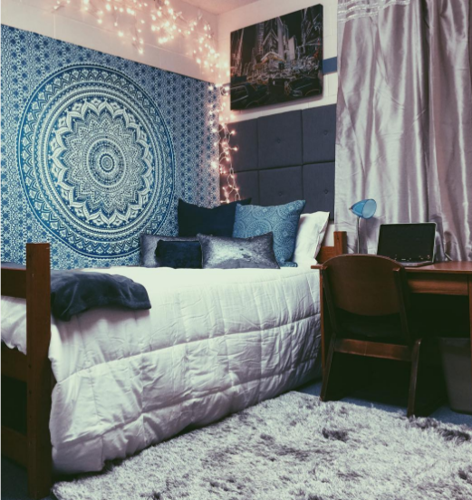 A student dorm room with a tapestry on the wall