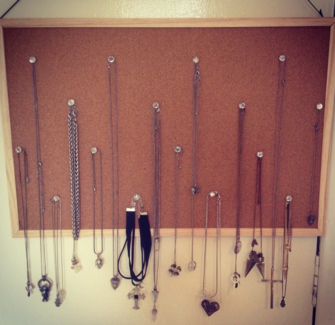 Necklaces hung on a cork board