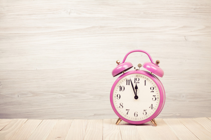 A pink alarm clock on a table