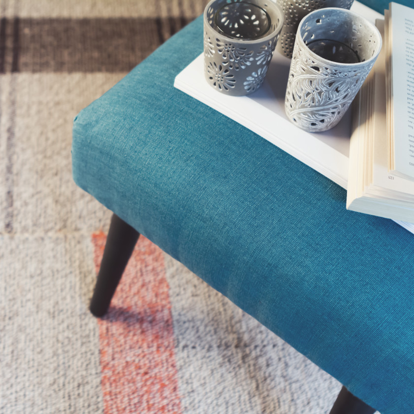 A dorm room with a rug on the floor