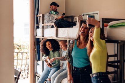 A group of university students taking a selfie in a student bedroom