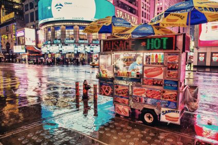 A hotdog cart on a street corner in New York City