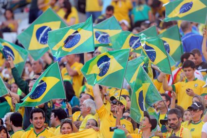People waving Brazil flags at a football game