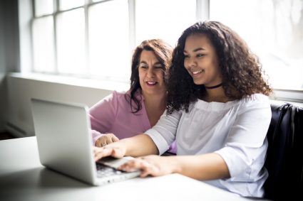 A young woman teaching an older woman