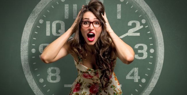 A stressed-looking woman in front of a clock