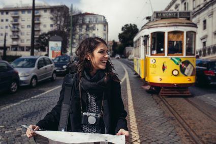 A young woman next to a tram in Lisbon