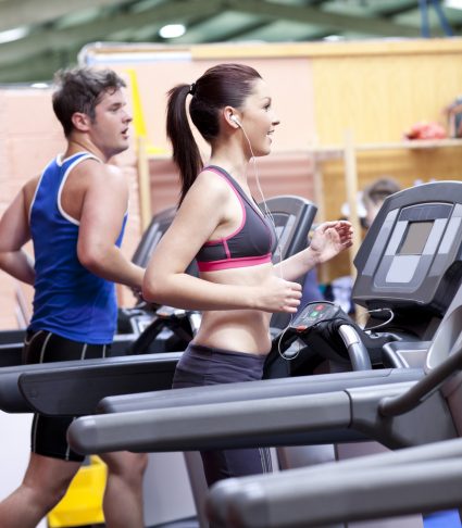 Two young people running on a treadmill