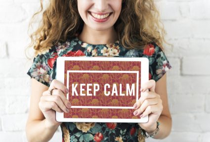 A woman holding a sign with the text "Keep calm"