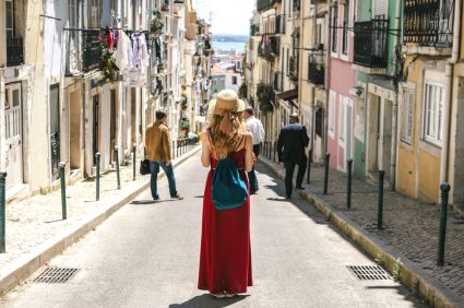 A young woman standing on a narrow street in Lisbon
