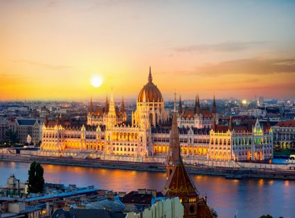 A view of Budapest at dusk, with the Danube in the foreground and the Hungarian parliament building behind it