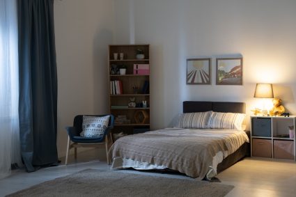 A reading lamp on a bedside table next to a bed