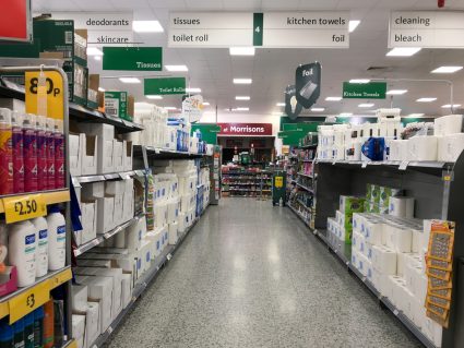 A supermarket aisle with toilet paper on the shelves