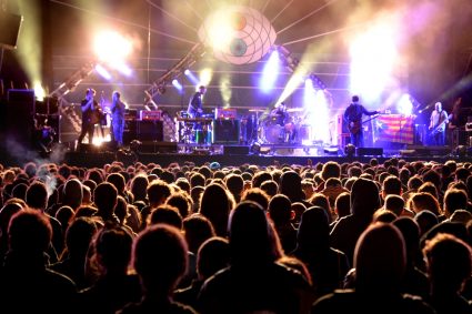 A group of people at a concert with a band playing on stage