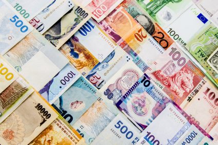 Piles of money in different currencies