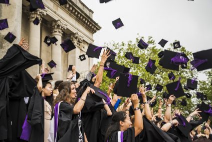 A group of graduating students throwing their hats in the air