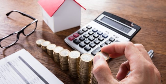 A pile of coins and a calculator for making a financial plan