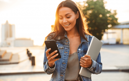 A young female student messaging her family on her phone