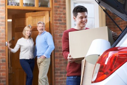 A student moving into his new apartment with the help of his parents