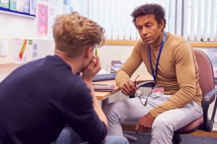 A young male student talking to a mental health professional