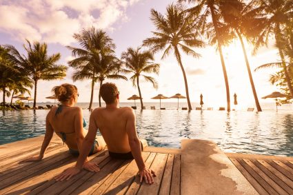 A couple sitting by the pool at a holiday resort