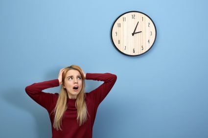 A stressed woman looking at a clock