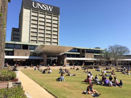 Students studying outside on the lawn at the University of New South Wales