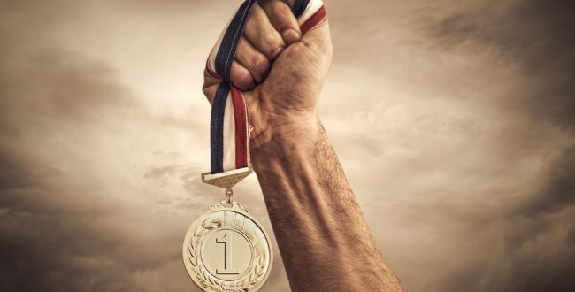 A hand holding a prize medal